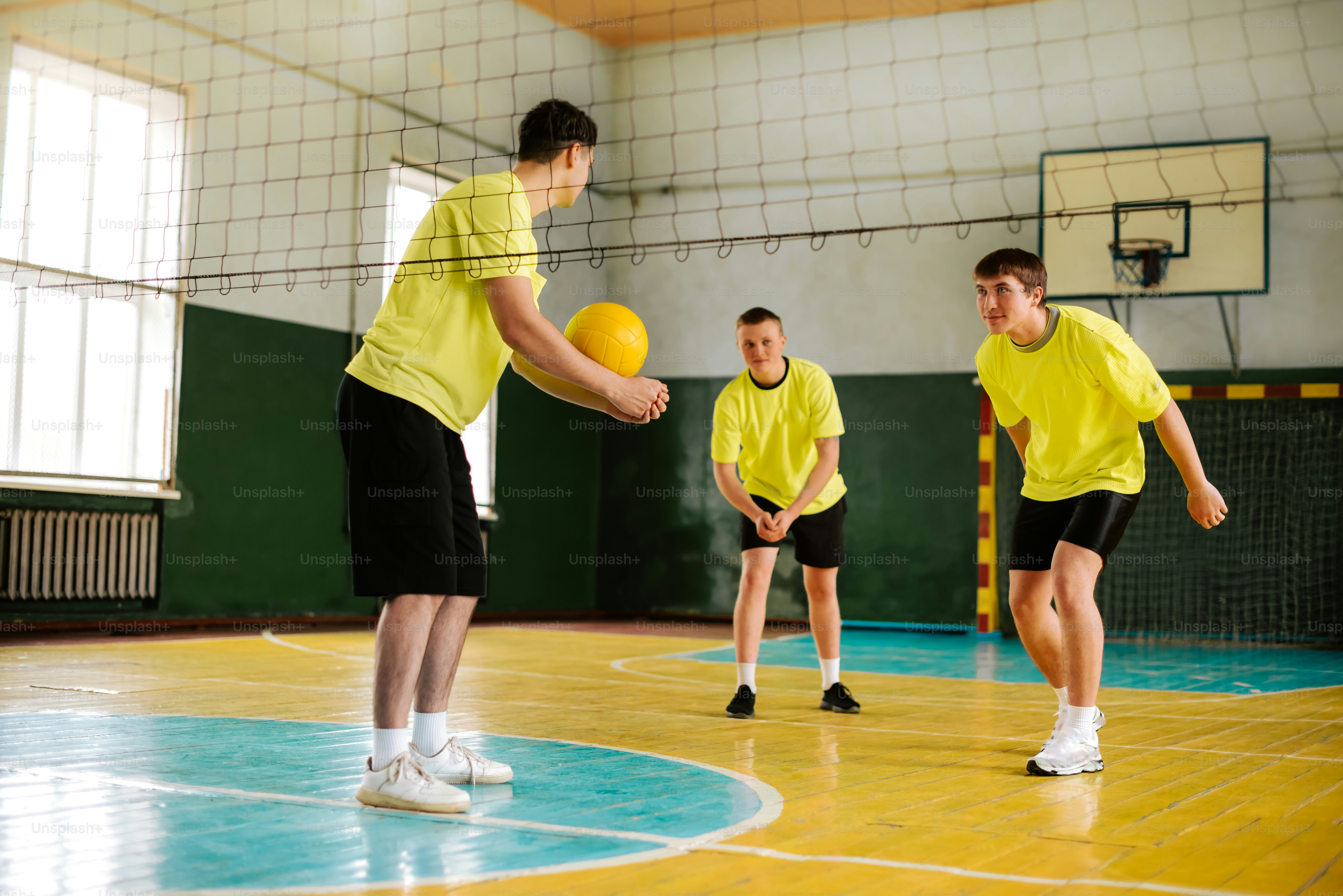 a group of young men playing a game of volley ball