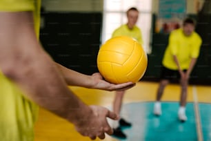a person holding a yellow ball in their hand