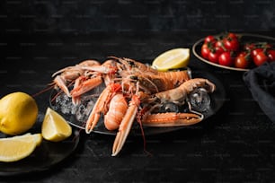 a plate of lobsters and lemons on a table