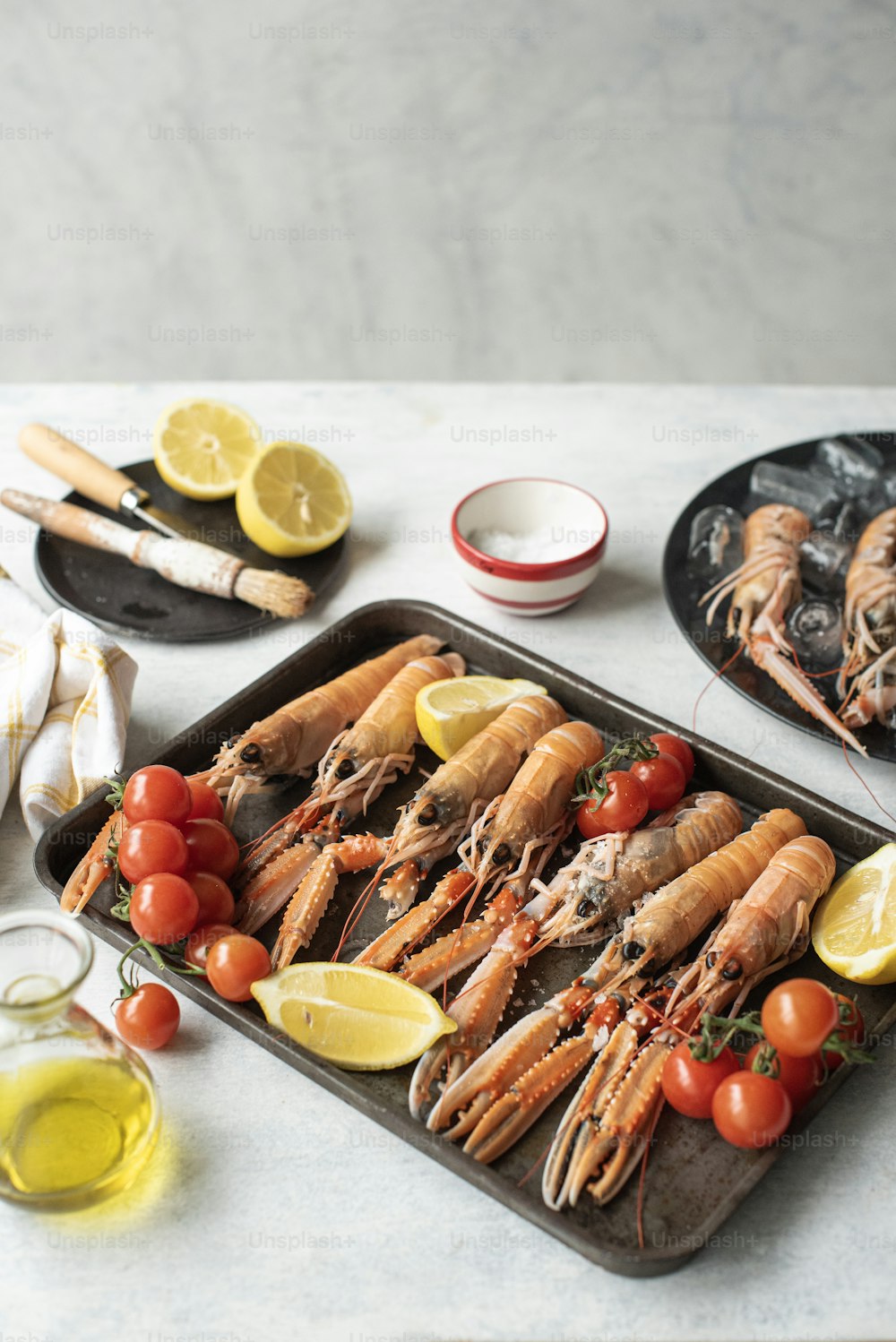 a tray of lobsters with lemons and tomatoes