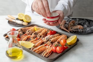 a tray of lobsters and lemons on a table