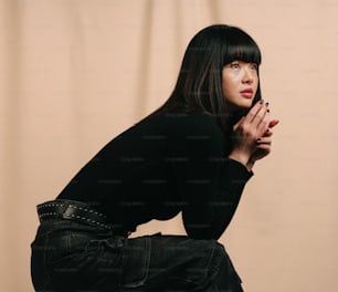 a woman sitting on the ground with her hands clasped