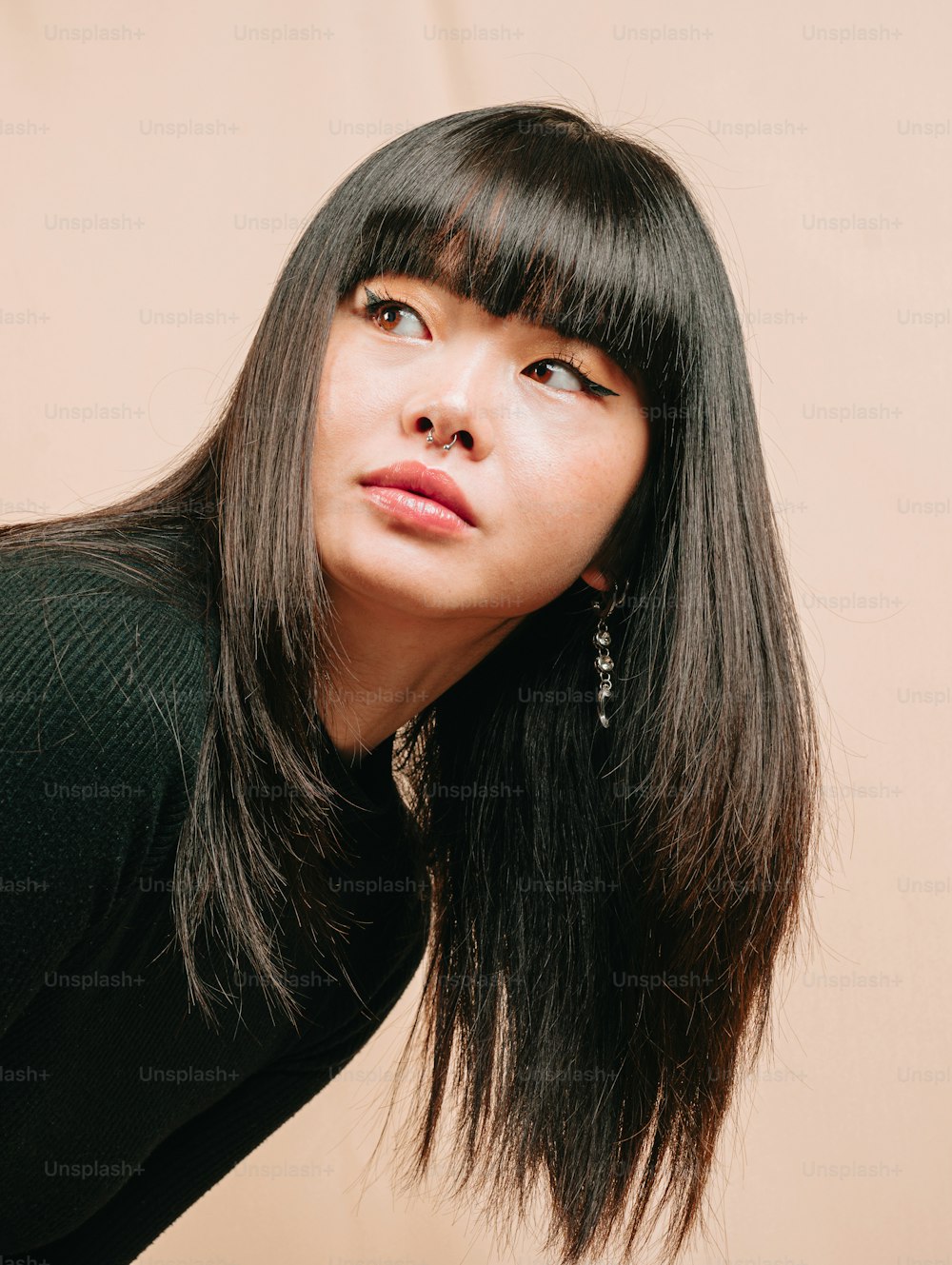 a woman with long black hair posing for a picture