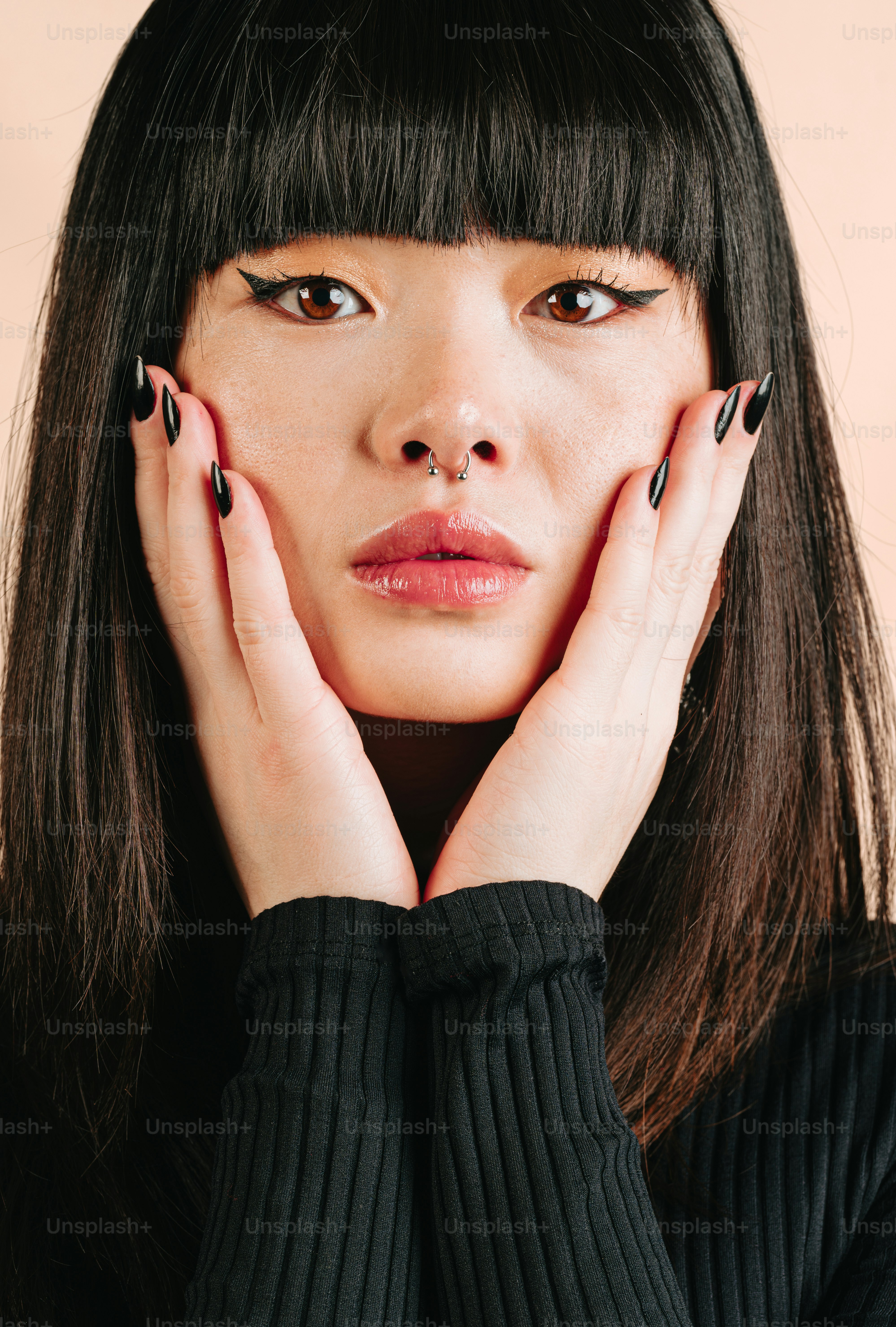 una donna con smalto nero che tiene le mani al viso