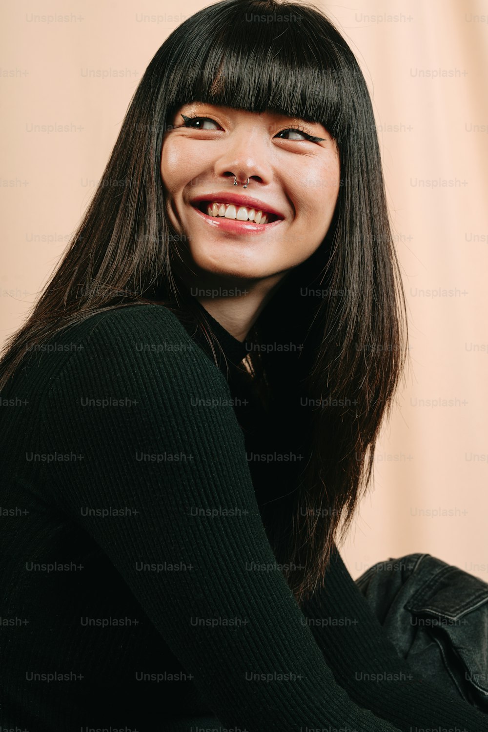 a woman with long black hair smiling at the camera
