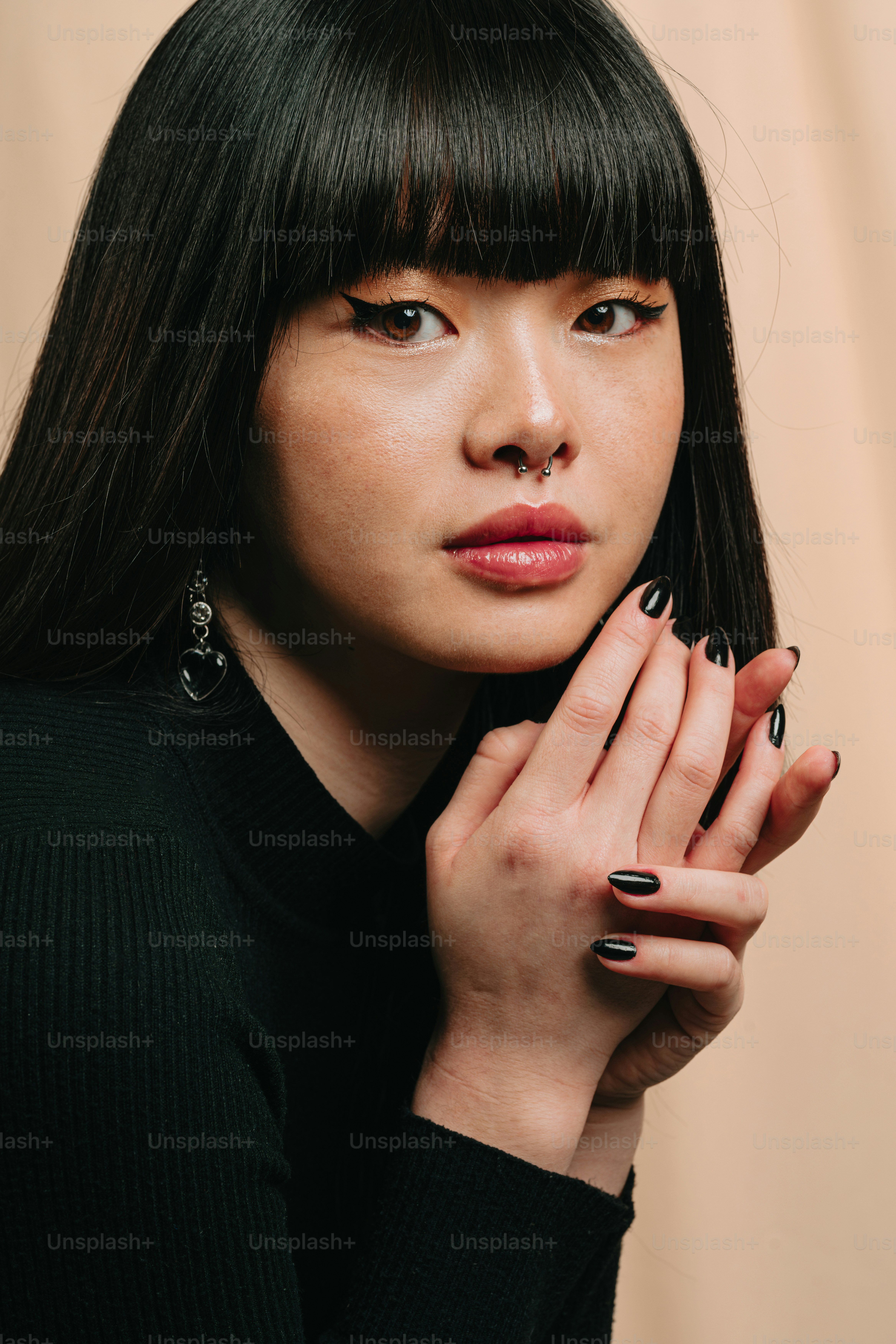 una donna con smalto nero che tiene la mano vicino al viso