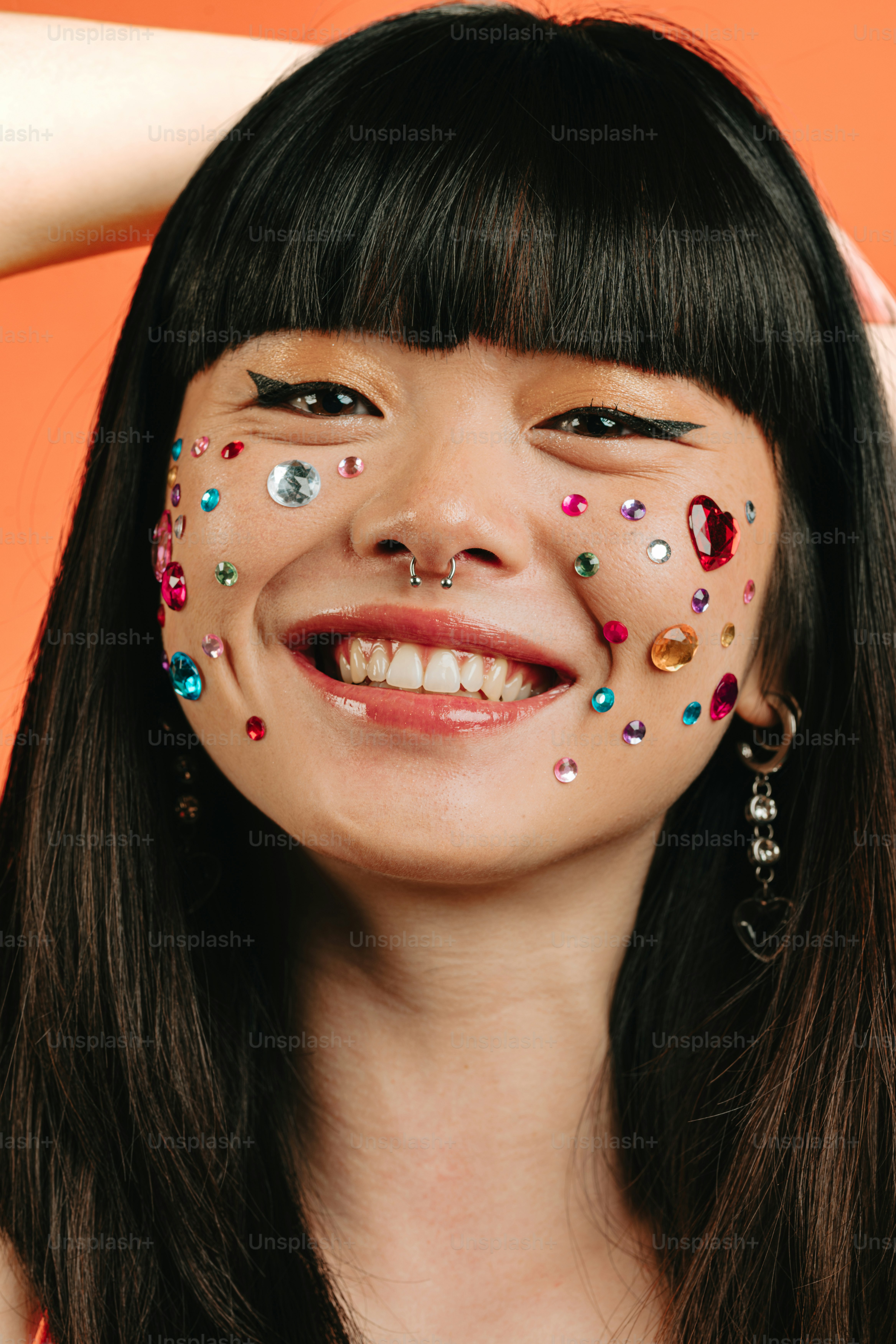 eine Frau mit einem Gesicht, das mit verschiedenfarbigen Streuseln bemalt ist