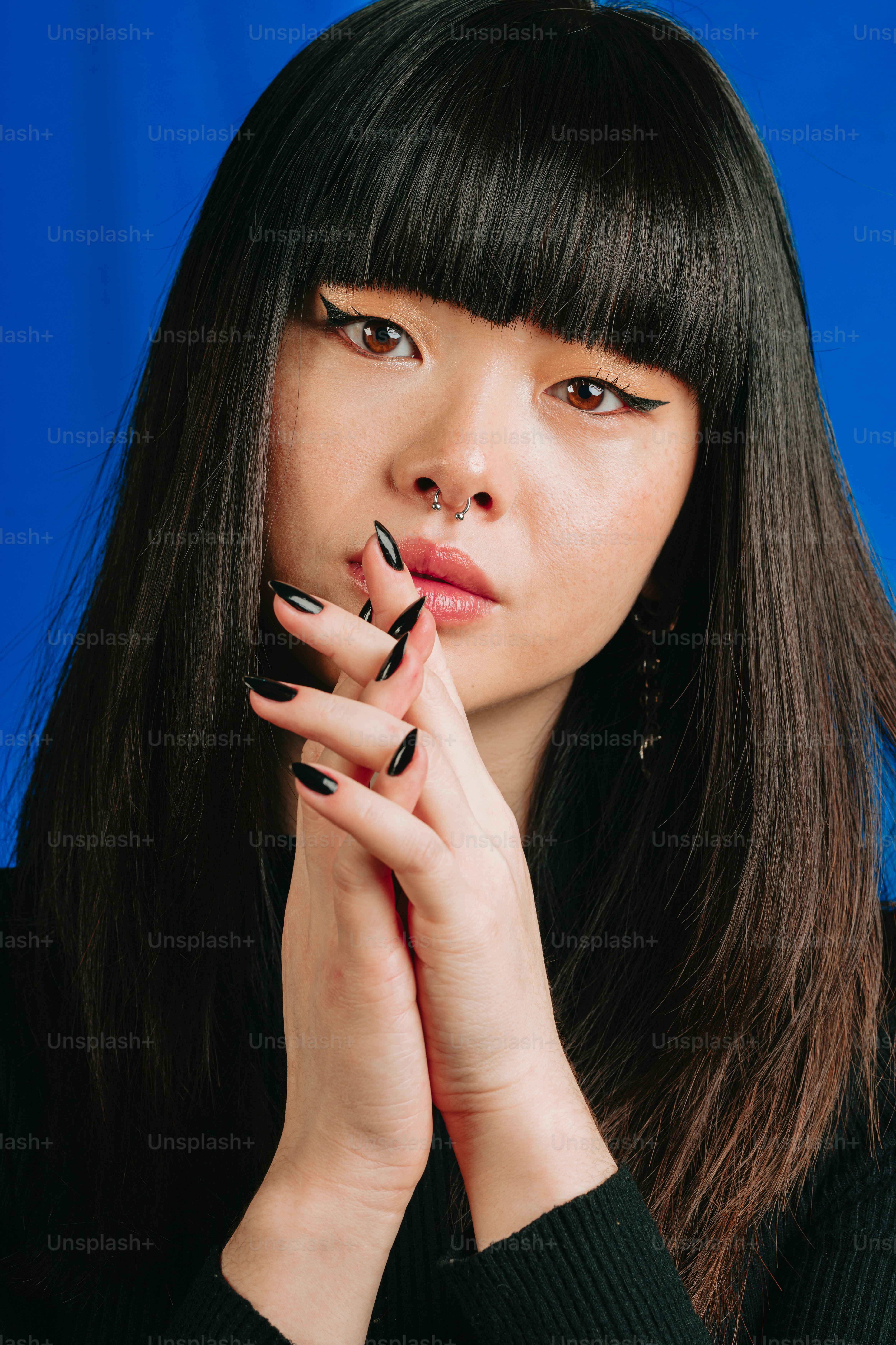a woman with black nails and a black sweater