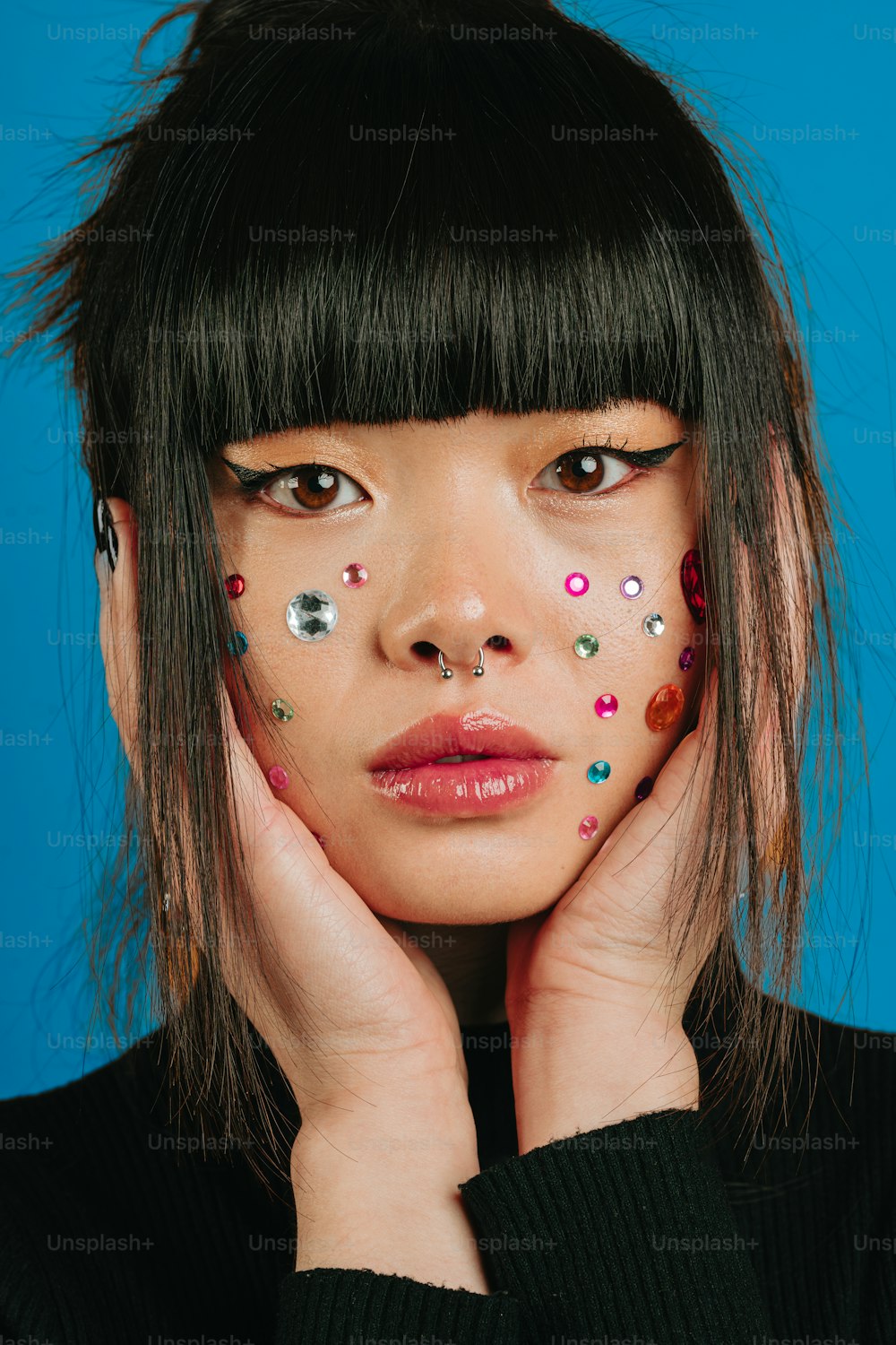 a woman with her hands on her face with sprinkles on her face