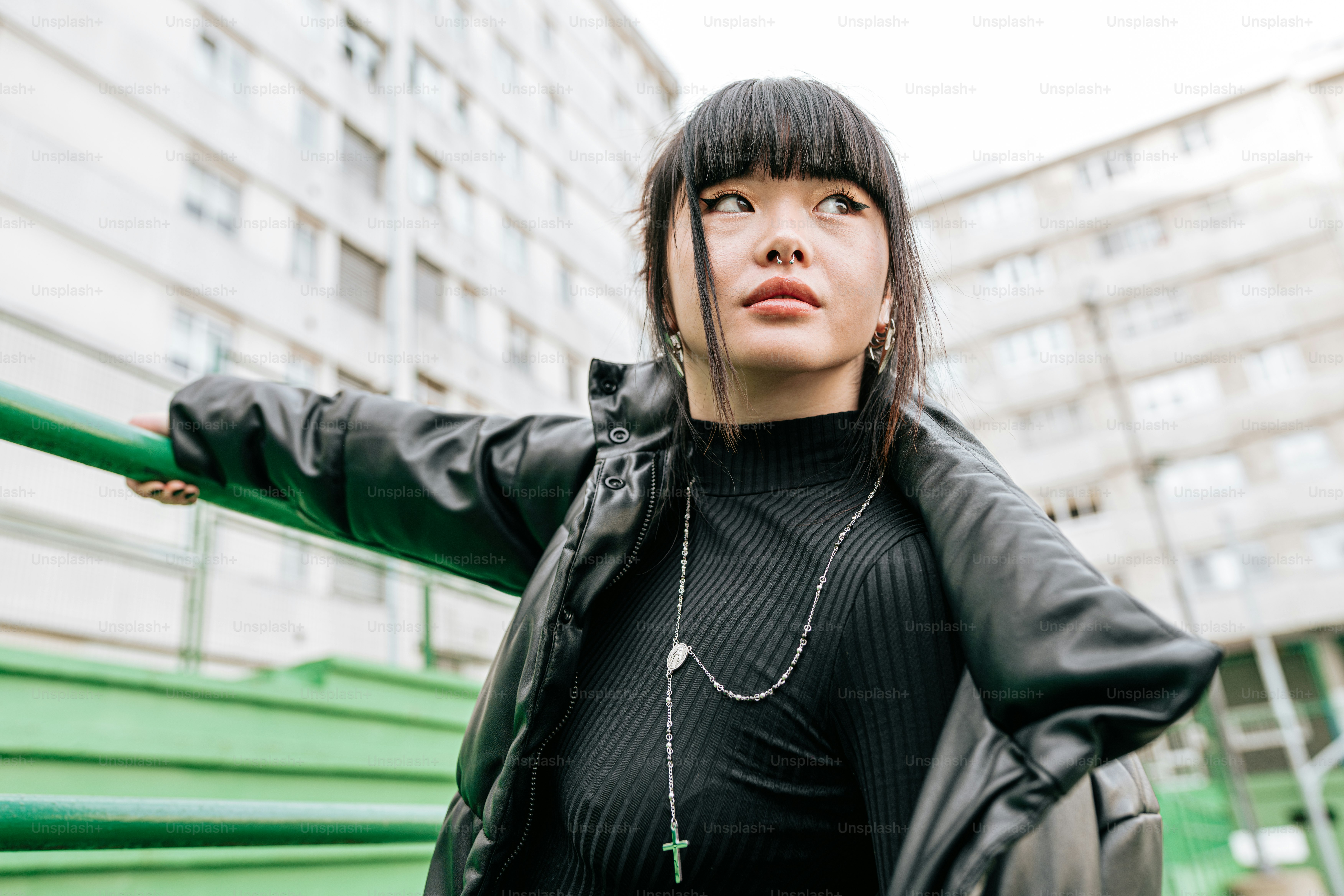 黒いトップスと緑の手すりを着た女性
