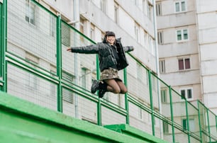 a woman in a black jacket is doing a trick on a skateboard