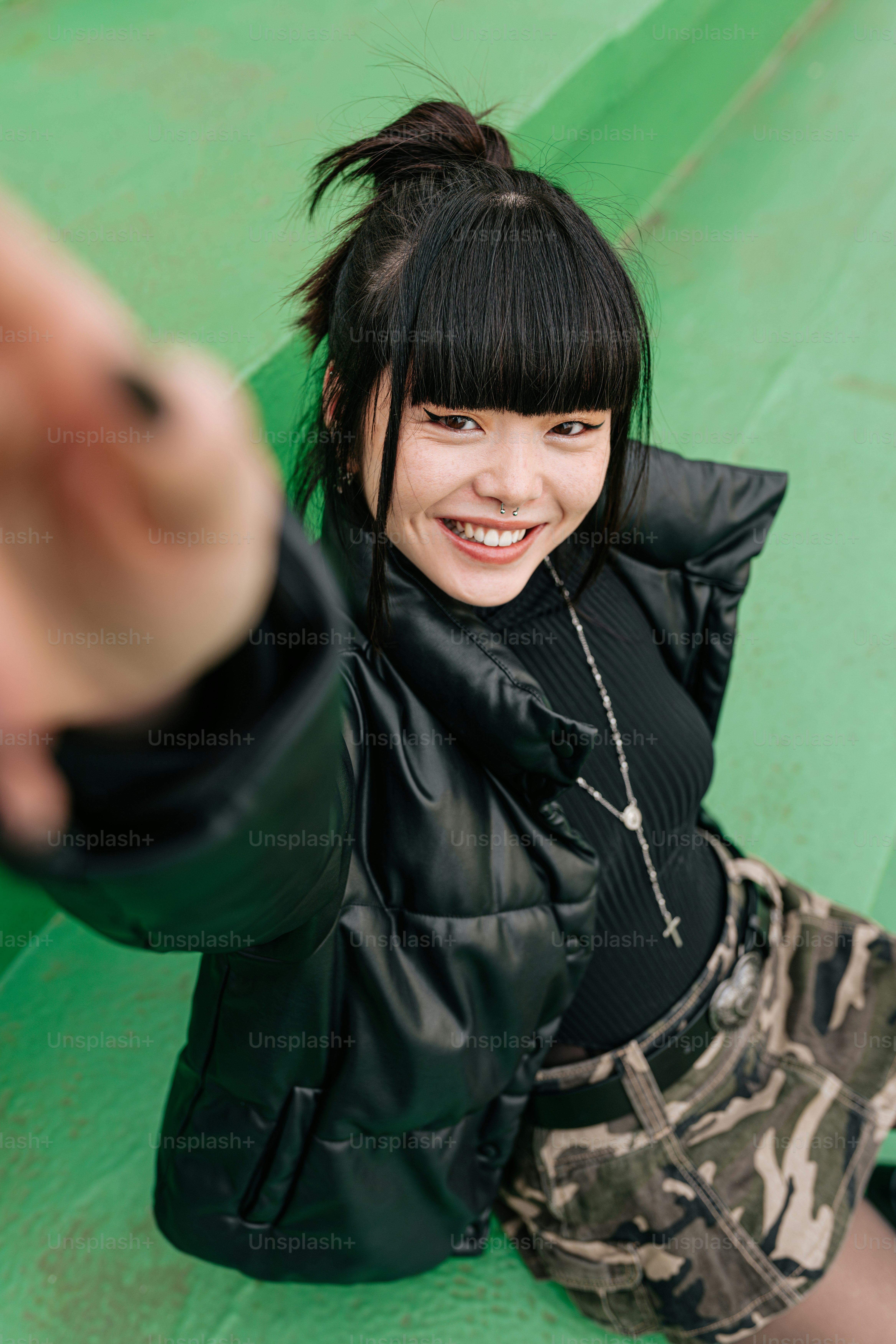 笑顔でカメラを指差す女性