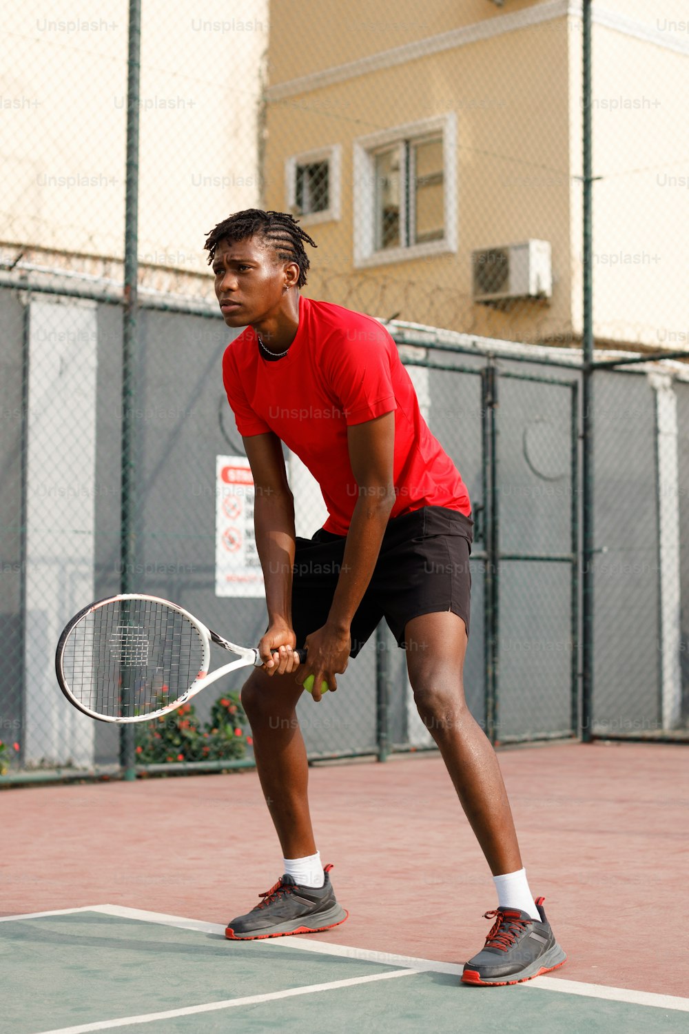 テニスコートでテニスラケットを持つ男性
