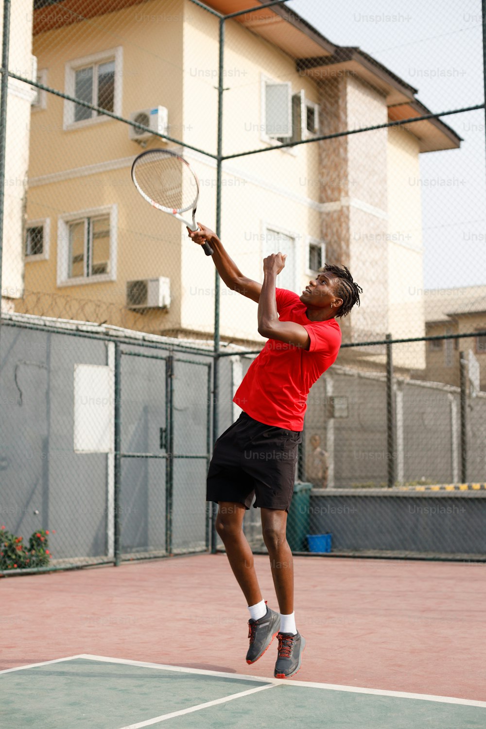 ein Mann, der in die Luft springt, um einen Tennisball zu schlagen