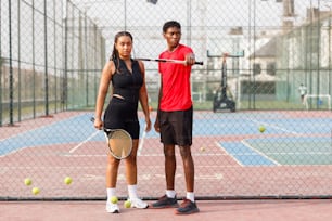 a man and a woman holding tennis rackets on a tennis court
