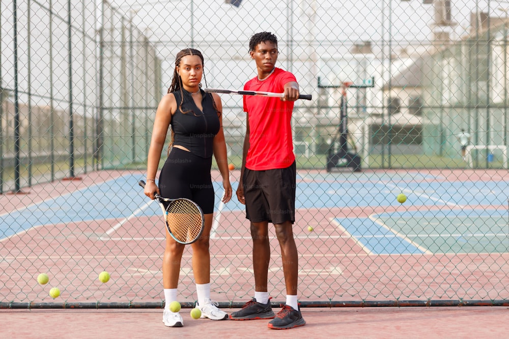 un homme et une femme tenant des raquettes de tennis sur un court de tennis