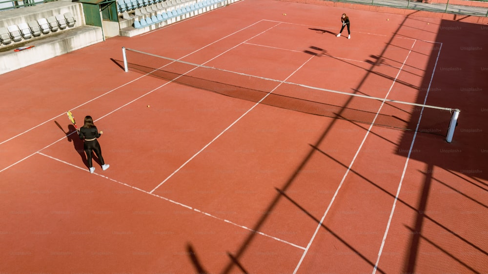 a couple of people standing on a tennis court holding racquets