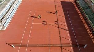 zwei Personen spielen Tennis auf einem Tennisplatz
