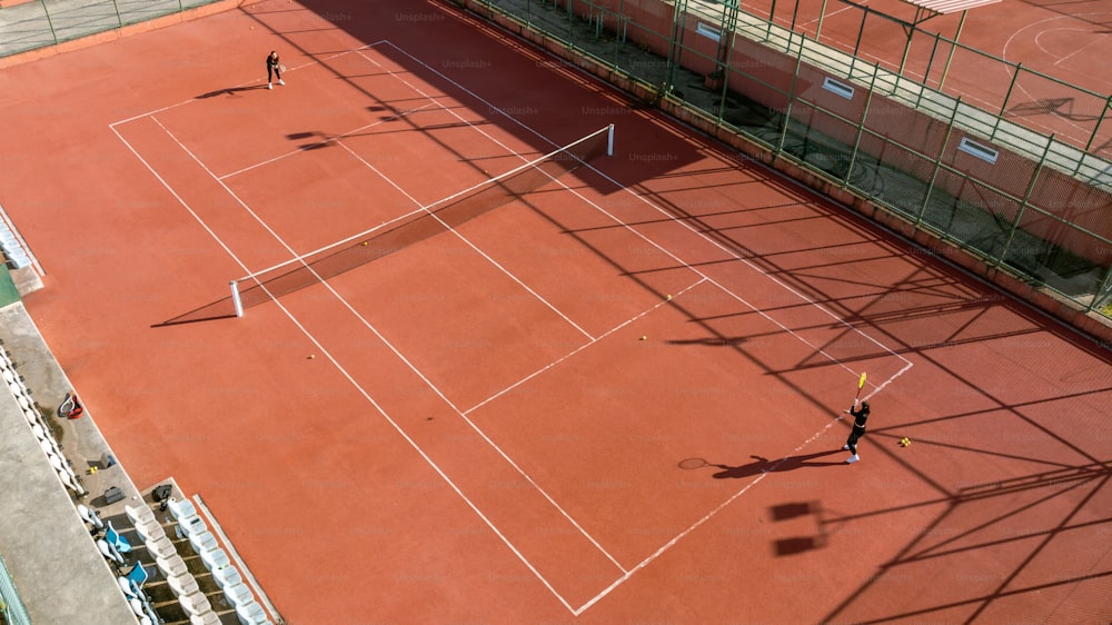 テニスコートでテニスをする2人