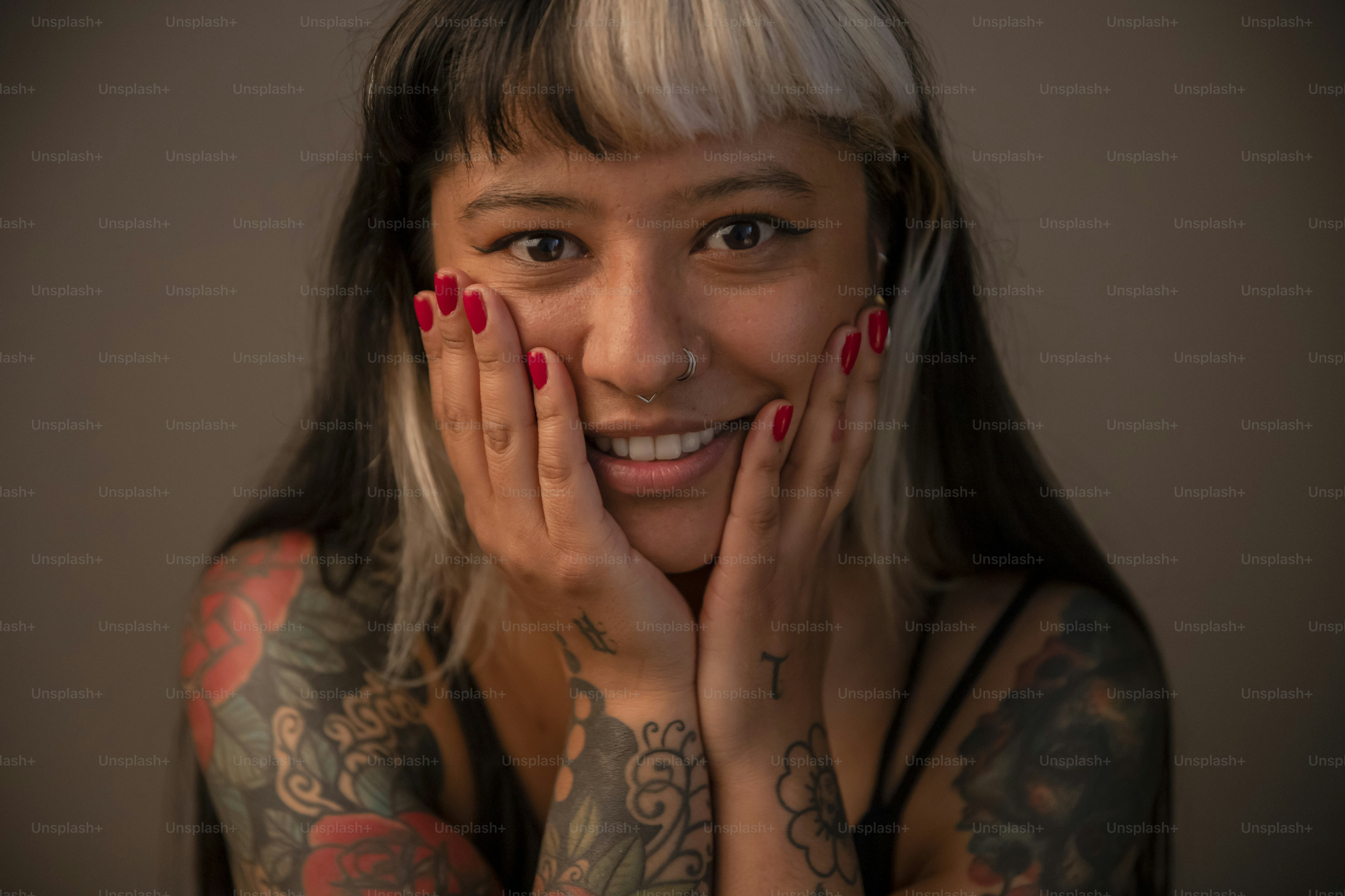 a woman with tattoos on her arms posing for a picture