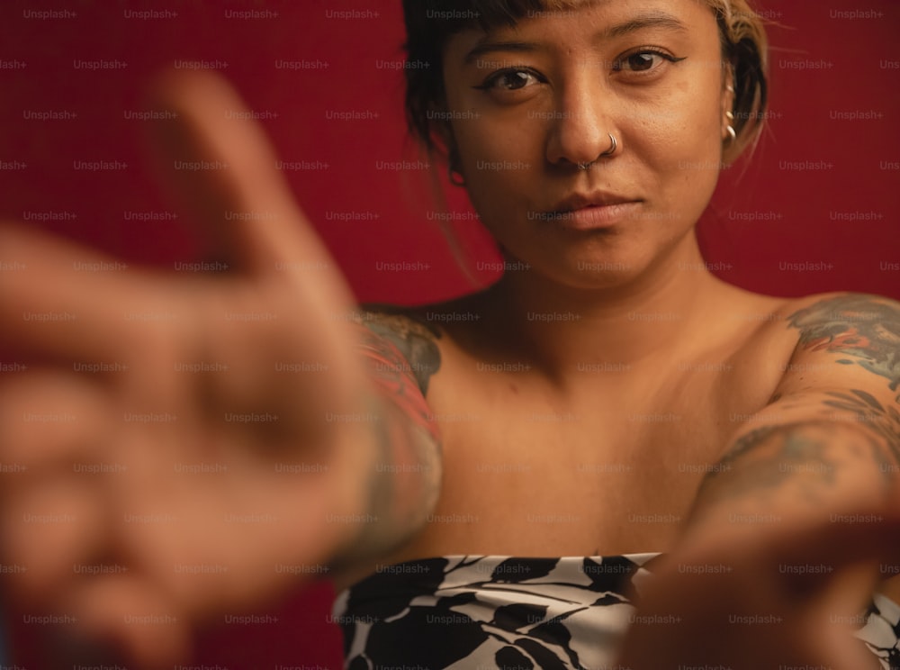 a woman with a tattoo on her arm making a peace sign