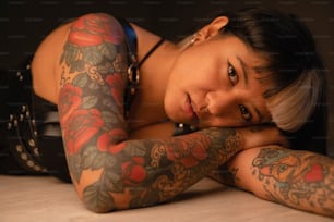 a woman with tattoos laying on a table