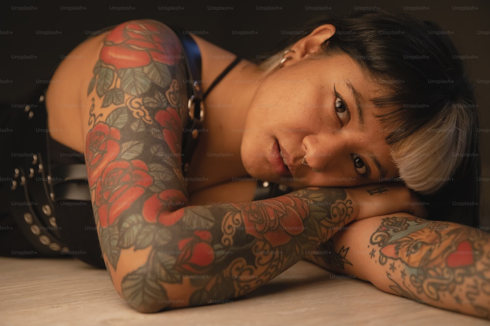a woman with tattoos laying on a table