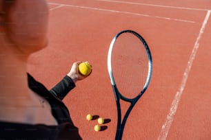 テ��ニスコートの上でテニスラケットを持つ女性