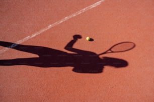 a shadow of a person holding a tennis racquet