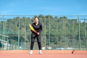 uma mulher segurando uma raquete de tênis em uma quadra de tênis