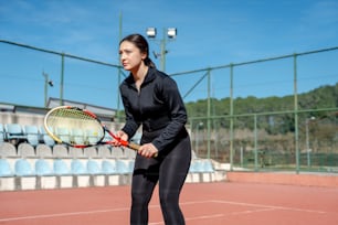テニスコートでテニスラケットを持つ女性