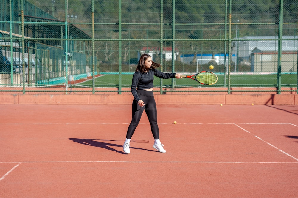 Una mujer está jugando al tenis en una cancha