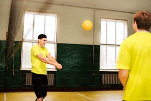 a man in a yellow shirt is throwing a yellow ball