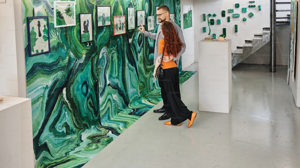 uma mulher em pé em frente a uma pintura em uma parede