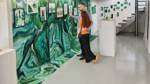 una mujer de pie frente a una pintura en una pared
