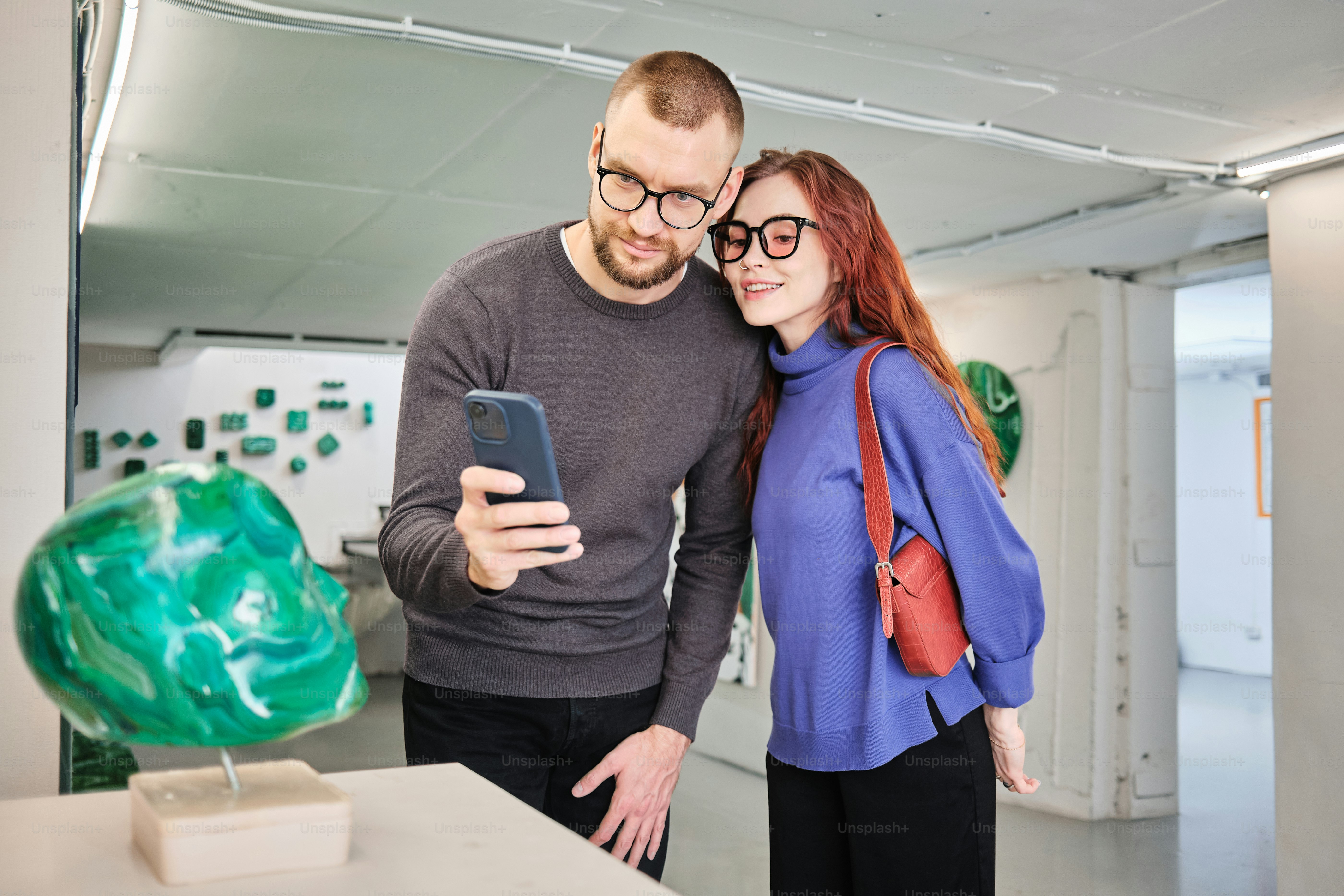 a man and a woman looking at a cell phone