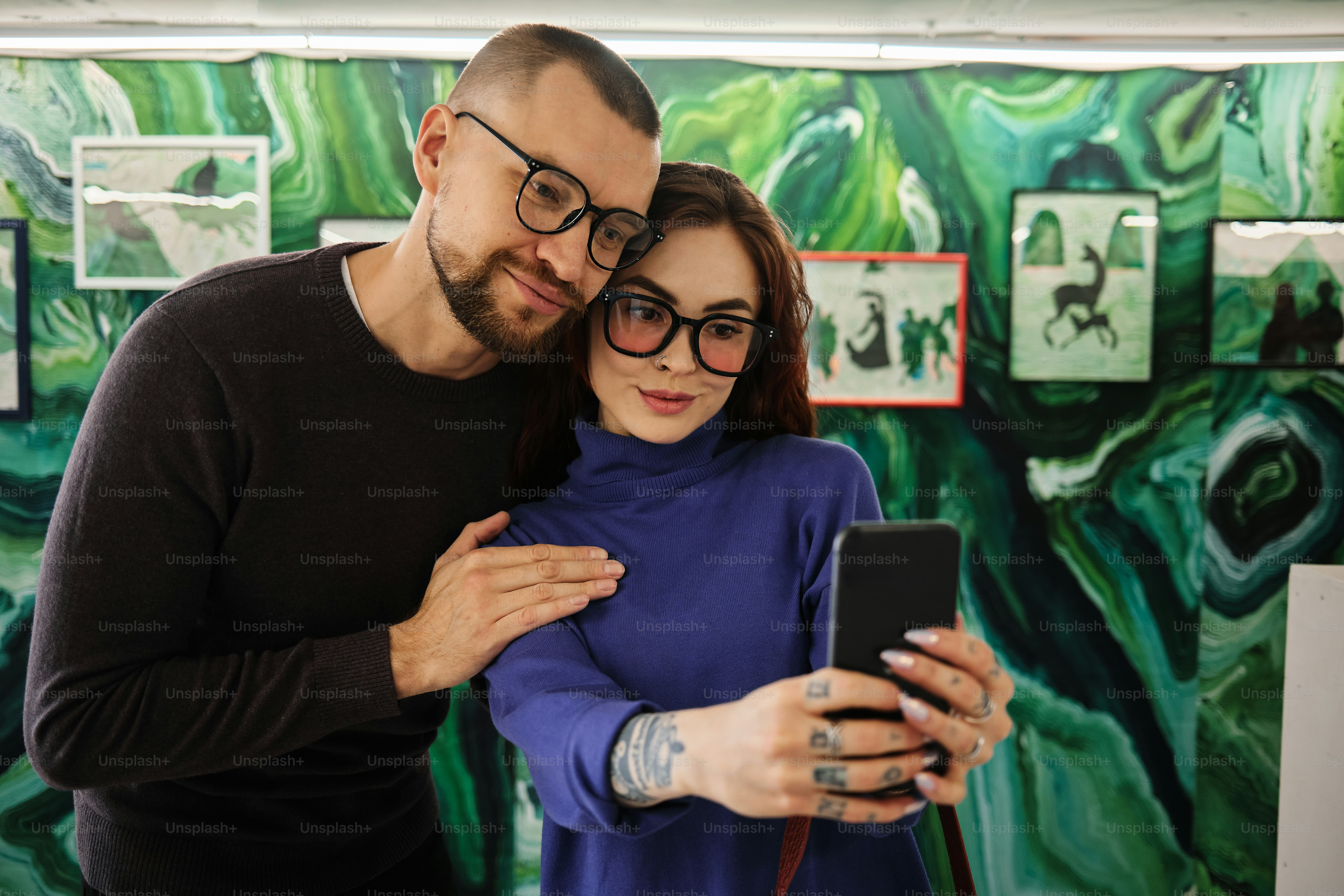 a man and a woman are looking at a cell phone