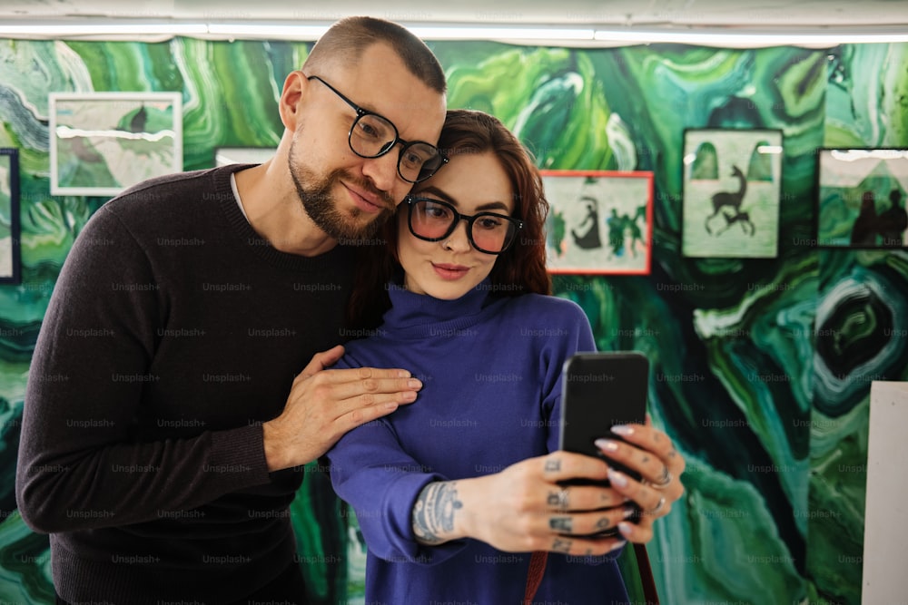 Um homem e uma mulher estão olhando para um celular