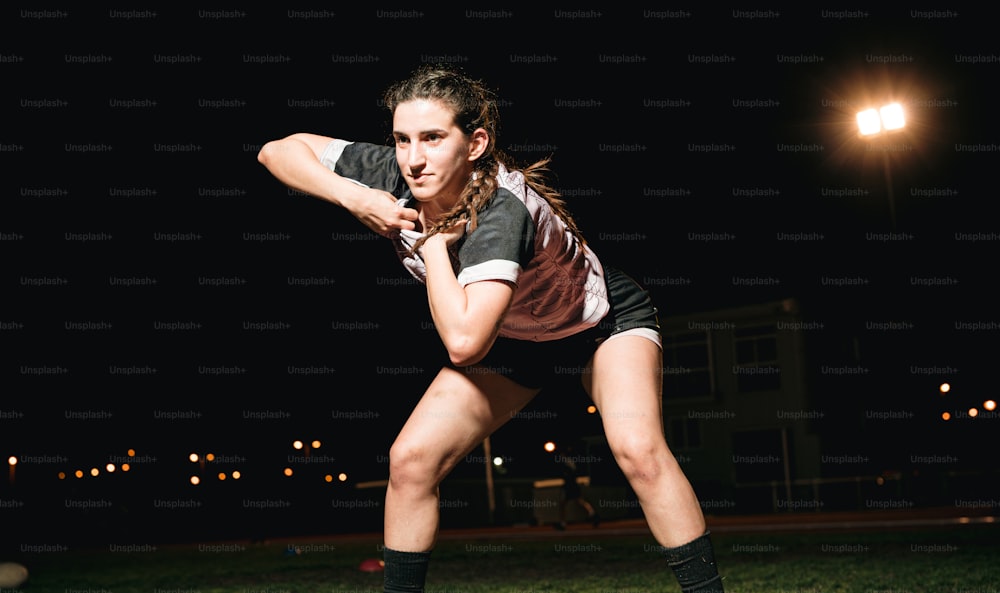 a woman in a black and white shirt is playing frisbee