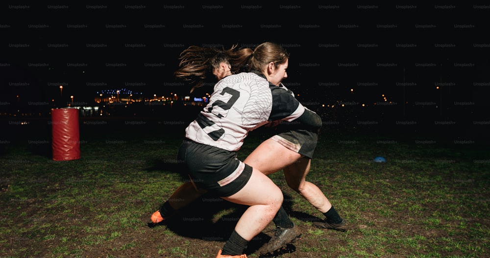 two women playing a game of frisbee at night