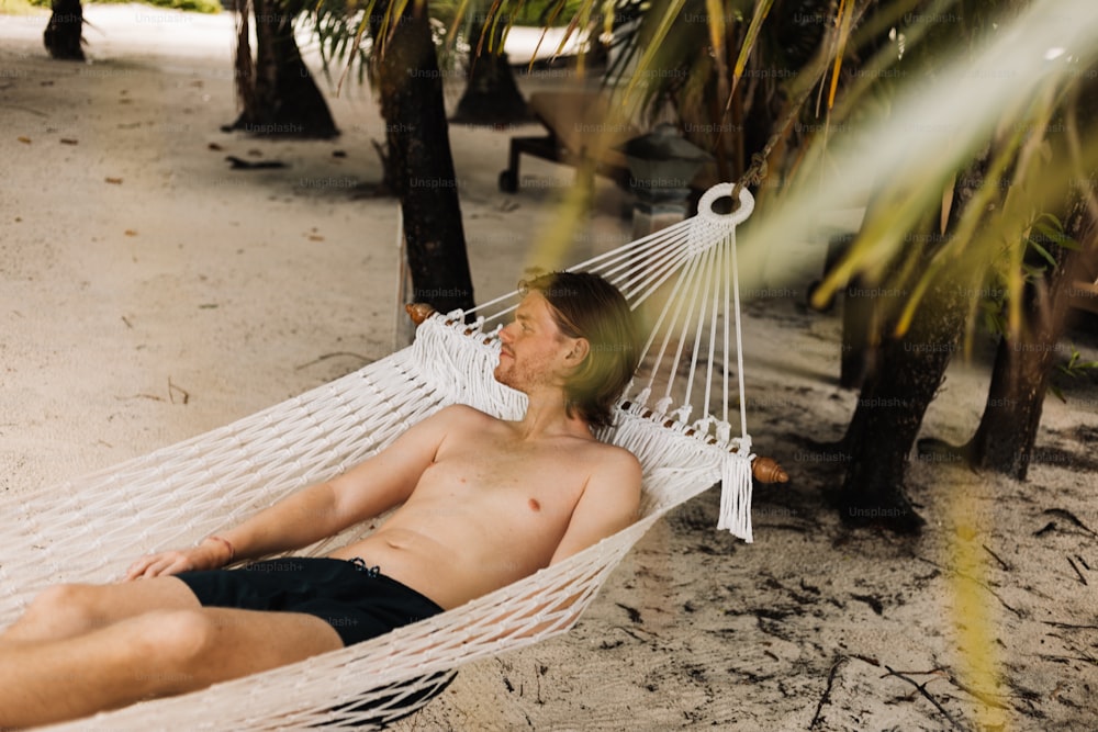 un uomo sdraiato su un'amaca sulla spiaggia