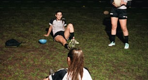 a woman sitting on the ground with a ball in her hand