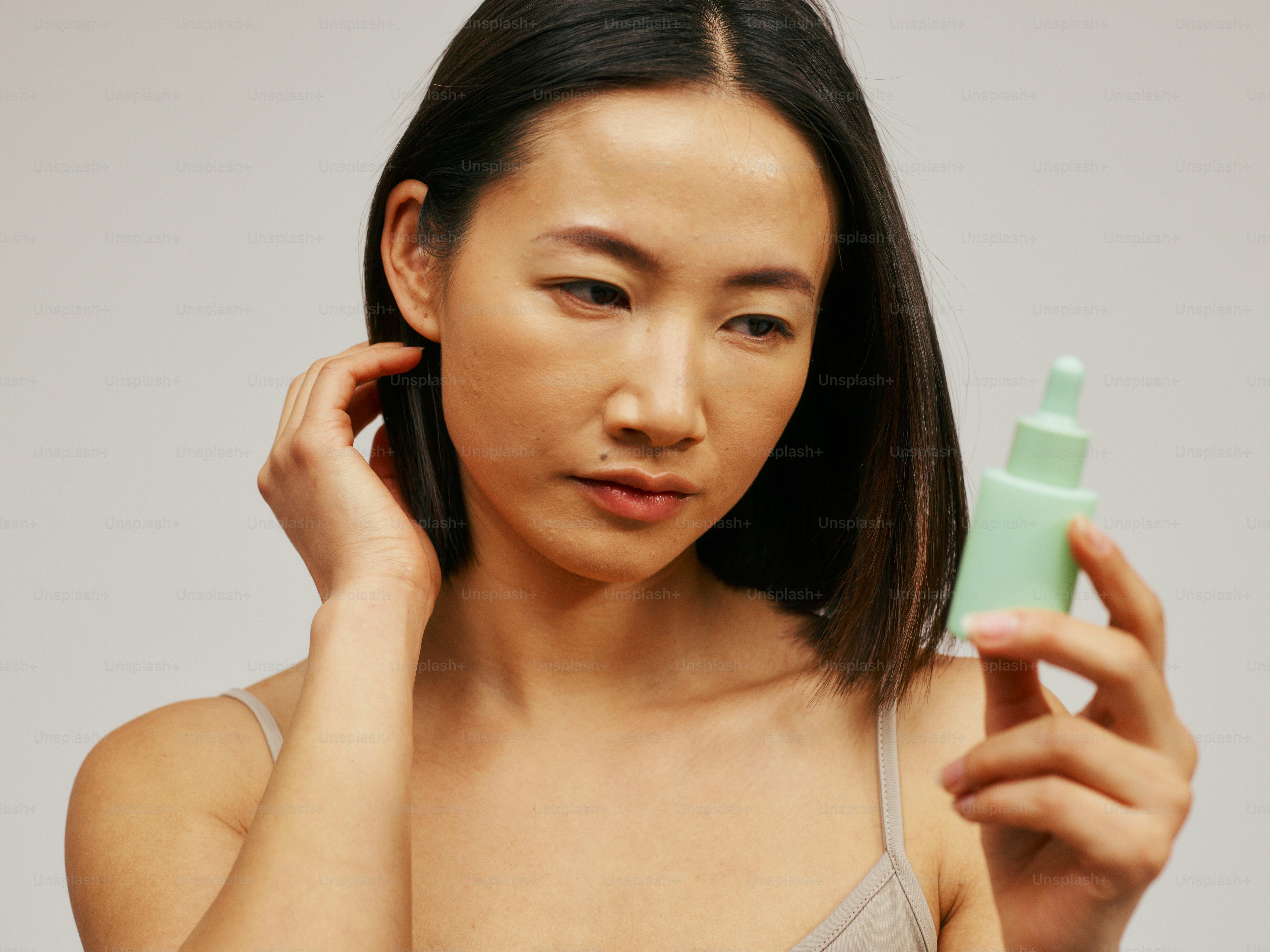 une femme tenant une bouteille de lotion dans sa main