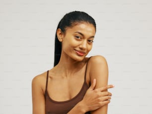 a woman in a brown tank top posing for a picture