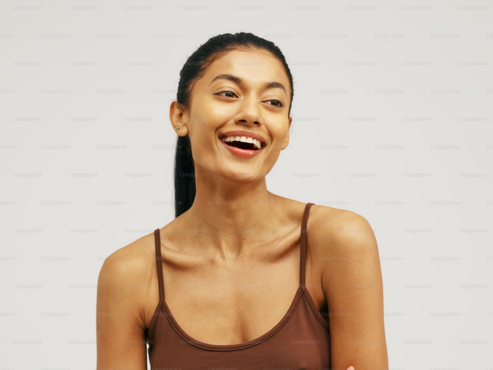 a smiling woman in a brown tank top