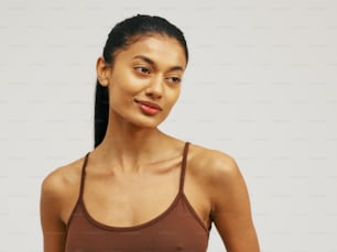 a woman in a brown tank top posing for a picture