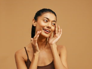 a woman is smiling and touching her face
