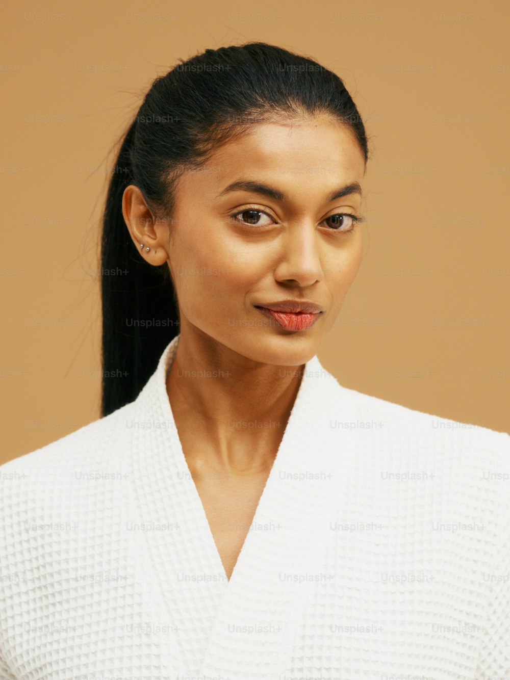 a woman with a ponytail wearing a white sweater