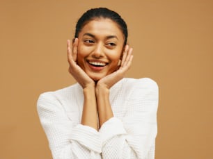 a smiling woman with her hands on her face