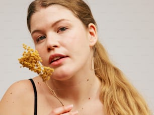 una mujer sosteniendo un montón de comida frente a su cara